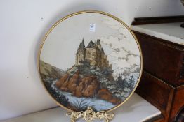 A good large Mettlach pottery charger depicting a castle on a mountainous landscape.