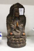 A moulded resin group of a seated deity.