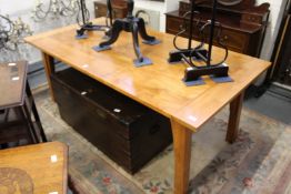 A good modern rectangular dining table with plank top on square supports.