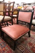 A Victorian ebonised and upholstered low occasional chair.
