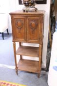A French walnut music cabinet, the pair of doors above two open shelves.