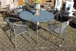 A circular metal garden table and four matching armchairs.