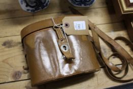 A leather cased pair of binoculars.