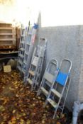 A quantity of aluminium step ladders and extending ladders.