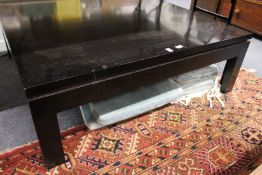 A large ebonised square shaped coffee table.
