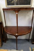 A pair of mahogany demi-lune side tables.