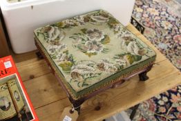 A small upholstered stool with trade label.