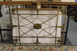 A heavy brass fireguard.