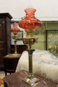 A good pair of Corinthian column brass oil lamps with ruby coloured shades.