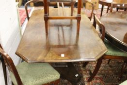 A 19th century mahogany pedestal dining table with a rectangular top and cupped corners on a