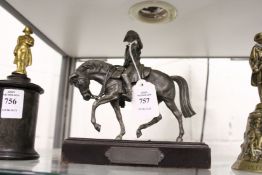 A cast metal model of Napoleon on horseback on a wooden plinth.