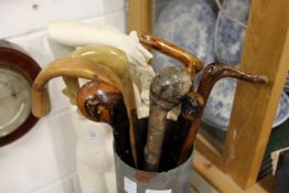 A large brass shell case containing walking sticks.