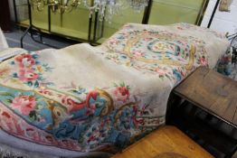 A Chinese cream ground oval carpet with floral decoration.