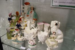 A Staffordshire spill vase modelled as man seated by a dog and other similar items.