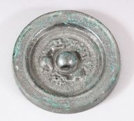 A CHINESE SILVERED BRONZE MIRROR, the centre with dragon motifs and script, 12.5cm diameter.