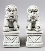A PAIR OF CHINESE BLANC DE CHINE / DEHUA PORCELAIN TEMPLE LIONS - one with its foot upon a ball