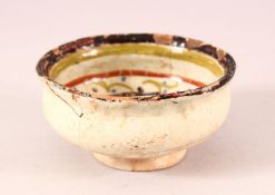 A SMALL ISLAMIC POTTERY BOWL, decorated with two birds, (af), 10cm diameter.
