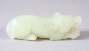 A CHINESE CARVED CELADON JADE PENDANT OF A DOG / BEAST - in a recumbent pose - 7.5cm