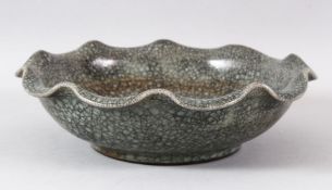 A LARGE CHINESE CRACKLE GLAZE BOWL, with wavy rim, the base with calligraphy, 23cm diameter.