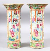 A PAIR OF CHINESE CANTON SLEEVE VASES, painted with panels of figures and bands of flora and