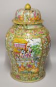 A LARGE CHINESE CANTON URN AND COVER, painted with panels of figures, profusely decorated with