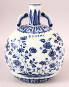 A CHINESE BLUE AND WHITE TWIN HANDLE PORCELAIN MOON FLASK, decorated with flowers, six character