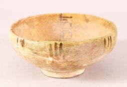 AN EARLY ISLAMIC POTTERY BOWL, interior with archaic script, 16cm diameter.