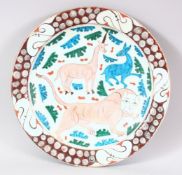 A GOOD LARGE IZNIK POTTERY DISH - decorated in an array of colour depicting animals and flora, 31cm