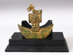 AN ARCHAIC STYLE BRONZE ZOOMORPHIC AXE HEAD on a wooden stand, the axe head, 15cm x 15.5cm.