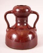 A CHINESE OX RED SPECKLED GLAZE TWIN HANDLE VASE, six character mark to base, 15.5cm high.