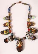 AN USUAL AFGHAN MULTICOLOURED GLASS NECKLACE, the pendant drops modelled as human faces,