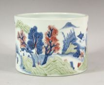 A CHINESE BLUE, WHITE AND COPPER RED BRUSH POT, the sides with a continuous scene of houses,