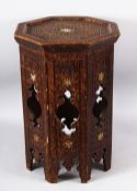 A MOORISH OCTAGONAL OCCASIONAL TABLE with carved decoration, 49cm high, 33cm wide.
