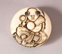 A JAPANESE MEIJI PERIOD CARVED IVORY KAGAMIBUTA NETSUKE - carved with the scene of a boy seated -