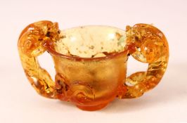 A CHINESE PEKING AMBER GLASS TWIN HANDLE CUP, with twin beast handles, 10cm wide.
