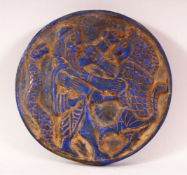 A CIRCLUAR LAPIS TABLET, carved with a male figure, lion and snake, 14cm diameter.
