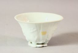A CHINESE BLANC DE CHINE PORCELAIN LIBATION CUP, with moulded floral decoration, 9cm wide.