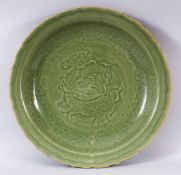 A CHINESE LONGQUAN OLIVE GREEN GLAZED PORCELAIN DISH - the interior carved with a beast, cloud and