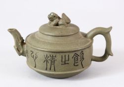 A CHINESE YIXING CLAY TEAPOT & COVER - decorated with calligraphy either side with a lion dog finial