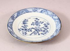 A SMALL 18TH CENTURY KANGXI BATAVIAN BLUE AND WHITE SAUCER, with floral decoration, 12cm diameter.