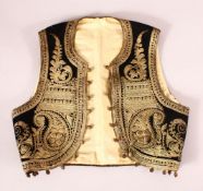 AN OTTOMAN EMBROIDERED BALKANS CHILD WAISTCOAT - with a black ground and gold coloured thread.