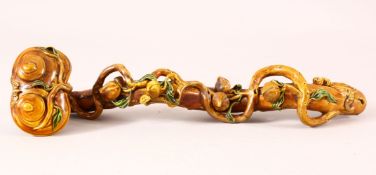 A CHINESE GLAZED PORCELAIN RUYI SCEPTER, naturalistically formed with moulded peach blossom, 34cm