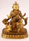 A CHINESE GILT BRONZE MODEL OF A DEITY, possibly Jambhala, seated upon a mythical creature, 22.5cm