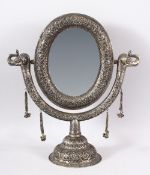 A GOOD INDIAN EMBOSSED WHITE METAL MORROR ON STAND - the mirror with twin elephant heads