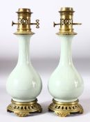A PAIR OF CELADON PORCELAIN VASES CONVERTED TO LAMPS with brass mounts, 40cm high.