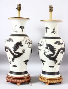 PAIR OF CHINESE CRACKLE GLAZE PORCELAIN LAMP VASES, on fitted wooden stands, the body of each with