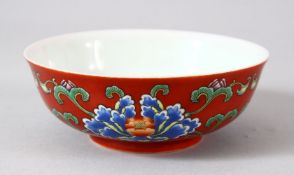 A CHINESE RED GROUND PORCELAIN BOWL, the exterior painted with blue flowers and foliate