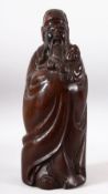 A CHINESE CARVED HARDWOOD FIGURE OF A SAGE AND CHILD - the large dense pice of timber carved to