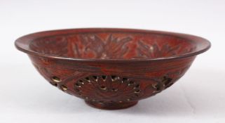 A CHINESE PIERCED POTTERY BOWL - the interior decorated with scenes of flora, the underside with