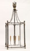 A LARGE SQUARE SHAPED GLAZED METAL HANGING LANTERN with four candle holders 48ins high, 16 ins
